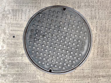 Şehrin Paved Caddesi. Atık su için metal bir kapağı var. Rögar kapağı, rögar kapağı, rögar kapağı paslı, grunge.