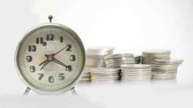 Saat ve para beyaz arkaplanda birikiyor, zaman kavramı değerlidir..