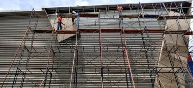 İnşaat işçileri şantiyedeki yüksek binalarda çalışıyorlar.. 