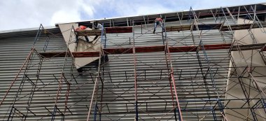 İnşaat işçileri şantiyedeki yüksek binalarda çalışıyorlar.. 