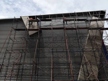 İnşaat işçileri şantiyedeki yüksek binalarda çalışıyorlar.. 