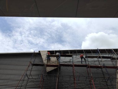 İnşaat işçileri şantiyedeki yüksek binalarda çalışıyorlar.. 