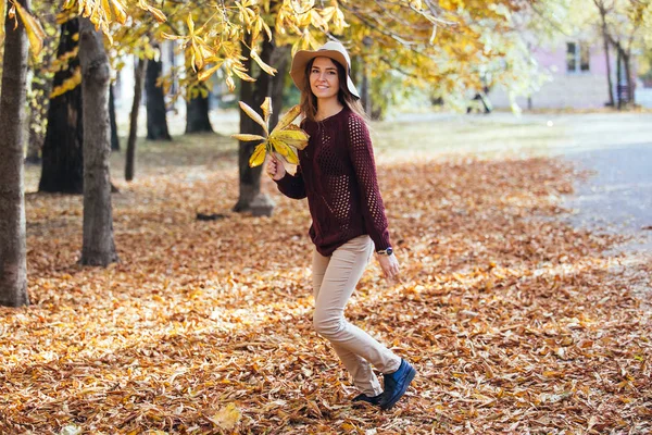 Happy young woman having fun time in autumn outdoors. Cheerful smiling girl jumping running in the fall forest. — Stock Photo, Image