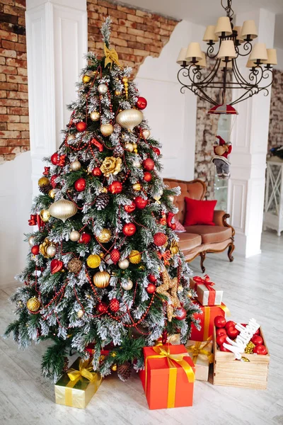圣诞和新年装饰室内 白墙前装饰着红色的礼物 圣诞树和经典的棕色沙发 — 图库照片