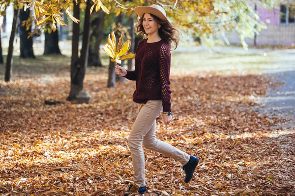 Happy young woman having fun time in autumn outdoors. Cheerful smiling girl jumping running in the fall forest. — Stock Photo, Image
