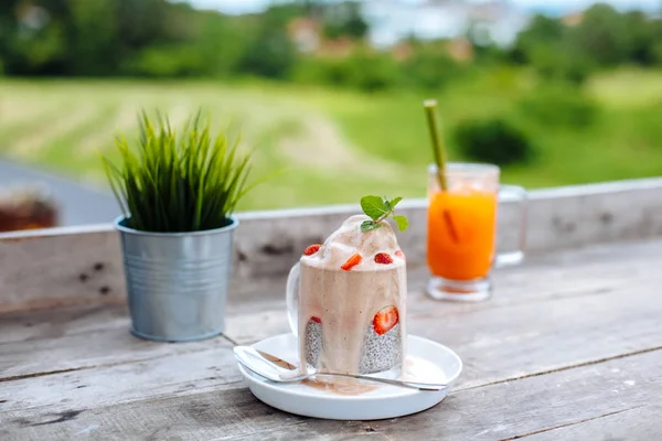 Food and drink, healthy eating and dieting concept. White chia pudding with fresh berries and carrot smoothies outdoor