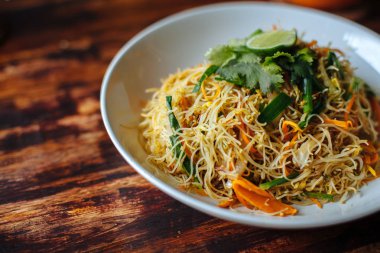 Sağlıklı vegan Vejetaryen menü Delicious Singapur tarzı heyecan kızarmış pirinç noodle havuç turuncu smoothies Cafe ahşap tablo ile.