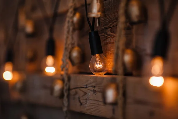 Hanging light bulb over the wooden background. Background wood planks with lamps