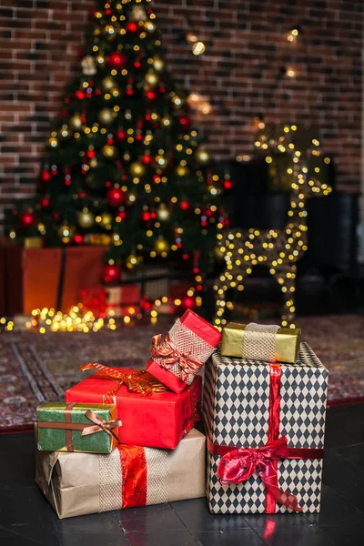 Noel hediyesi kutusunu kapat. Yılbaşı hediyeleri kırmızı ve kahverengi kutularda Noel ağacı arka planında tavan arası fotokopi alanında. — Stok fotoğraf