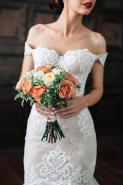 Düğün. Gelin el buketi. Seksi wtite gelinin elbise koyu arka plan üzerinde kırmızı dudaklar