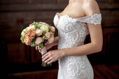 Düğün. Gelin el buketi. Seksi beyaz elbise koyu arka plan üzerine gelin. metin için yer