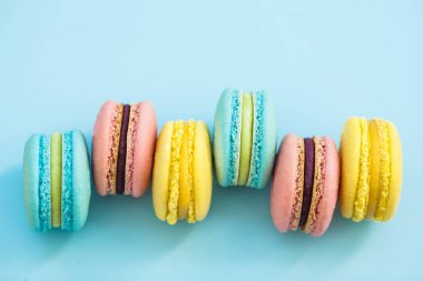 Mavi pastel renkli, üstten görünüm üzerinde tatlı renkli Fransız acıbadem kurabiyesi kurabiye. Macarons yatıyordu yelpazesi paylamak.