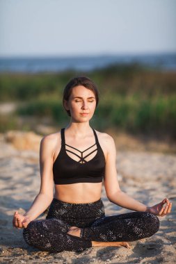 genç kadın içinde Lotus kum plaj gözlerine kapanış ile konum. Uzay kopyalayın. Sağlıklı stil