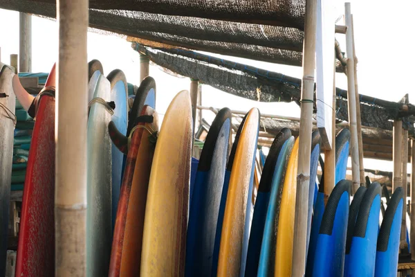 Set of different color surf boards in a stack by ocean.Bali.Indonesia. Surf boards on sandy beach for rent. Surf lessons on Weligama beach, Sri Lanka. — Stock Photo, Image