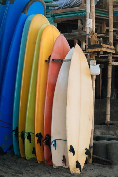 Set of multicolored surf boards in a stack by ocean.Bali.Indonesia. Surf boards on sandy beach for rent. Surf lessons on Weligama beach, Sri Lanka.