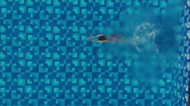 Bir kadın atlama ve havuza dalış ve su altında yüzer gibi yukarıdan görünümü. Sportif kadın yüzücü. havadan görünüm. Drone