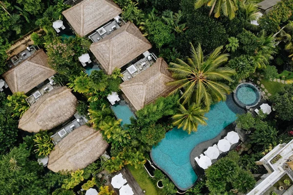 Légi kilátás luxus hotel szalma tetővel villák és medencék trópusi dzsungelben és pálmafák. Luxus villa, pavilon az erdőben, Ubud, Bali — Stock Fotó