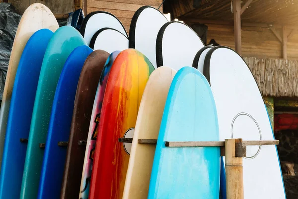 Conjunto de tablas de surf de diferentes colores en una pila por océano.Bali.Indonesia. Tablas de surf en la playa de arena en alquiler. Clases de surf en la playa de Weligama, Sri Lanka. — Foto de Stock