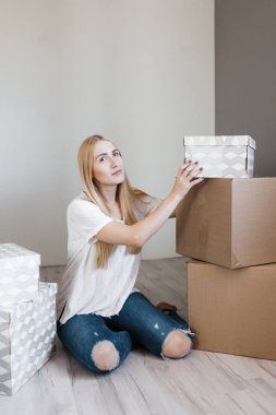 Genç sarışın gülümsemek kadın karton kutular tehcir sonra katta oturan çevrili