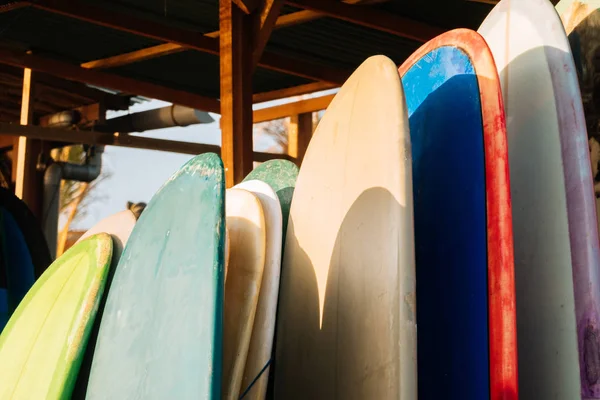 Σύνολο πολύχρωμο surfboard για ενοικίαση στην παραλία. Πολύχρωμες σανίδες surf διαφορετικά μεγέθη και χρώματα σανίδες surfing στο περίπτερο, ιστιοσανίδες ενοικίασης θέση — Φωτογραφία Αρχείου