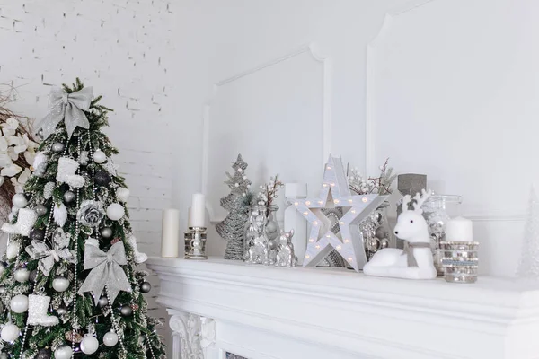 Natal e Ano Novo decorações brancas e prateadas na lareira no quarto interior branco com árvore de Ano Novo. Conceito de Natal — Fotografia de Stock