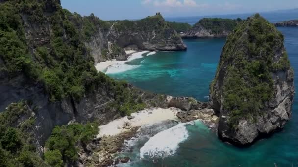 Vista aérea de la verde costa tropical con agua turquesa y rocas de la isla de Nusa Penida, Atuh Beach, Bali — Vídeos de Stock