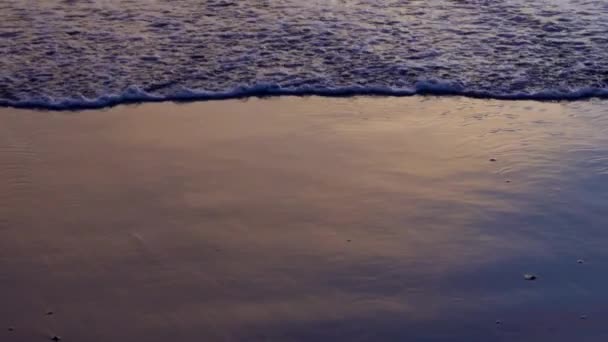 Närbild video av vågor med skum rulla upp svart vulkanisk sand ocean beach, Bali, Indonesien — Stockvideo