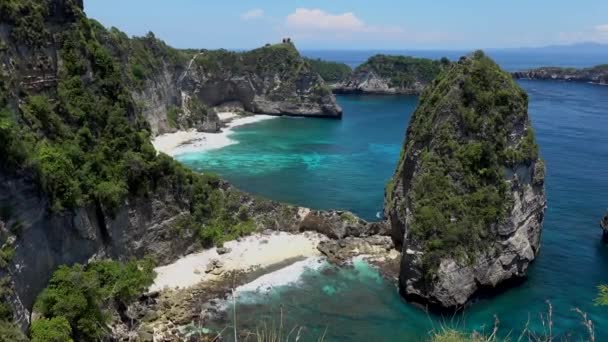 Vue aérienne sur la plage tropicale, les rochers marins, l'océan turquoise et les palmiers. Plage d'Atuh, île de Nusa Penida, Bali, Indonésie. Contexte tropical et concept de voyage — Video