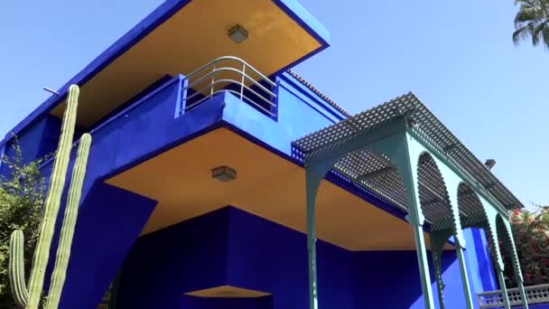 Marokkó, Marrakech - 2019. október: Kék és sárga építészeti épület a Jardine Majorelle kertben, Afrika, Yves Saint Laurent Múzeum — Stock videók