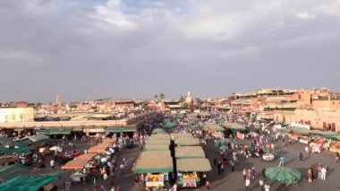 Fas, Marakeş - Ekim 2019: Alacakaranlıkta Jemaa el-Fna Meydanı 'nın en üst manzarası, gün batımında yeşil çadırlı ve şemsiyeli insanların alışveriş merkezleri arasında taşınması