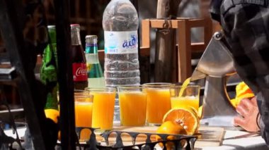 Fas, Todra - Ekim 2019 Fas 'lı adam portakal suyunu elle sıkıyor, Fas' taki bir markette bir bardak taze portakal suyu yapıyor.