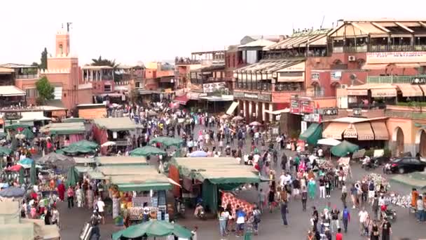 Marruecos, Marrakech - Octubre 2019: Vista de la plaza Jemaa el-Fna al atardecer con personas moviéndose entre filas de puestos de mercado desde la vista superior en la hora del atardecer — Vídeos de Stock