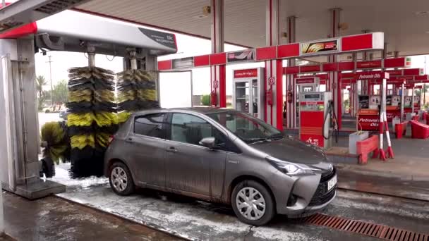 Μαρόκο, Μαρακές - Οκτώβριος 2019: Αυτόματη διαδικασία πλυσίματος αυτοκινήτων έξω στο βενζινάδικο, μακριές βούρτσες που περιστρέφονται και καθαρίζουν μικρό αυτοκίνητο. Εξοπλισμός αυτόματου πλυντηρίου αυτοκινήτων — Αρχείο Βίντεο