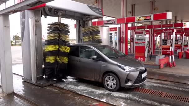 Fas, Marakeş - Ekim 2019: Otomatik araba yıkama işlemi benzin istasyonunun dışında, uzun siyah ve sarı fırçalar dönüyor ve arabayı temizliyor. Otomatik oto yıkama ekipmanı. Araba yıkama eylemi — Stok video