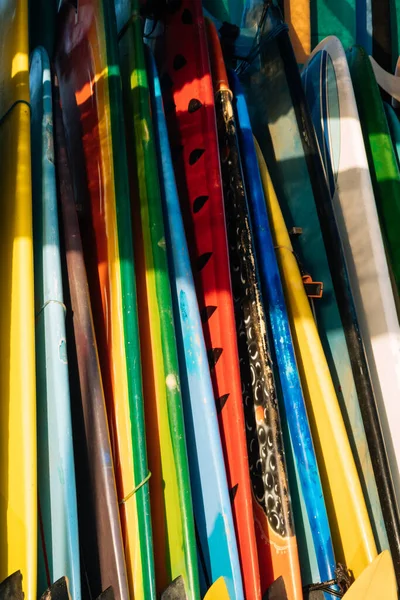 Set of different color surf boards in a stack by ocean.Bali.Indonesia. Surf boards on sandy beach for rent. Surf lessons on Weligama beach, Sri Lanka