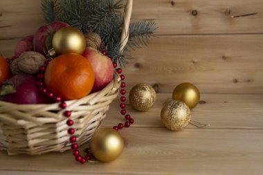 Sıcak bir ahşap arka plan üzerinde portakal, elma, Noel ağacı ve Noel oyuncakları ile bir sepet içinde Noel kompozisyon, tatil kavramı
