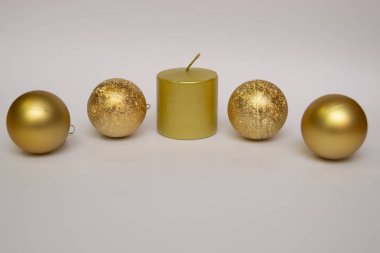 Altın toplar ve altın bir mum. Beyaz arka plan. Noel ve kutlama.