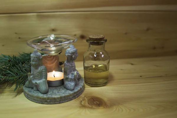 Aromatik lamba, Buda figürleri, çam ağaçları, kozalaklar, mum, masa üzerinde bir şişe aromatik yağ. Tahta sıcak arka plan. Sağlığa. Önlem olarak. Alternatif tedavi. Aromaterapi
