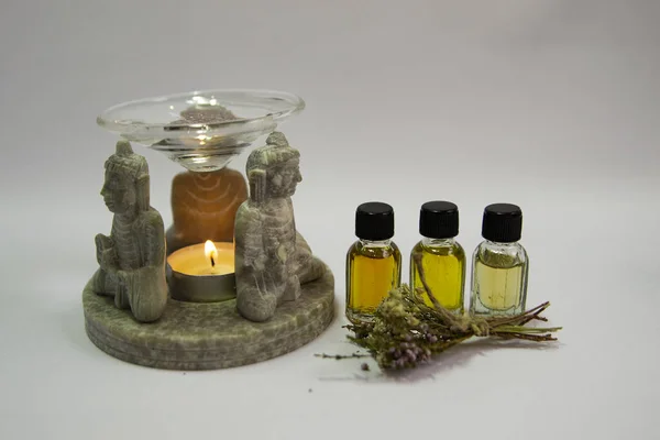 Kokulu lamba, Buda figürleri, mum, kokulu yağ şişesi. Bir şişe yağ. Beyaz arka plan. Aromaterapi. Sağlık. Gribi önleme.