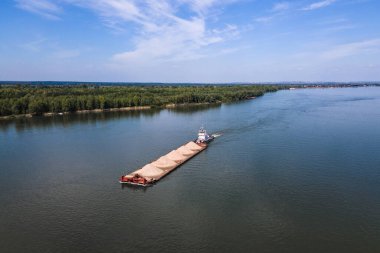 Gemi nehir boyunca kumlu bir mavnayı itiyor. Uçaktan nehrin manzarası.