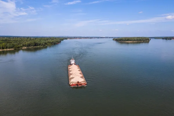 the ship is pushing a barge with sand along the river. view of the river from the plane.