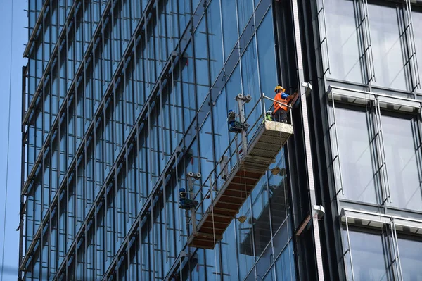 Lavoratori Edili Una Piattaforma Sospesa Una Facciata Vetro Grattacielo — Foto Stock