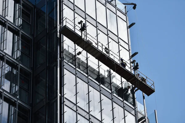 Byggnadsarbetare Svävande Plattform Skyskrapa Glasfasad — Stockfoto