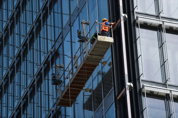 Byggnadsarbetare Svävande Plattform Skyskrapa Glasfasad — Stockfoto