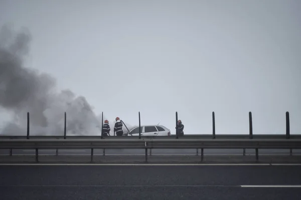 Feuerwehr löscht brennendes Auto auf Autobahn — Stockfoto