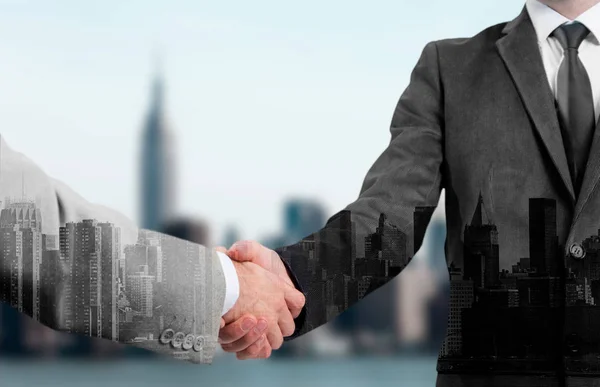 Double exposure of two business people handshake and city. — Stock Photo, Image