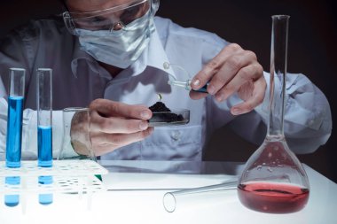 Genç adam bir tıbbi bilim laboratuvar şişesi ile otomatik pipet kullanarak bilim adamı. Araştırmacı kavramı.