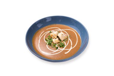 Kızarmış balkabağı ve kremalı havuç çorbası ve beyaz arka planda kabak çekirdeği..