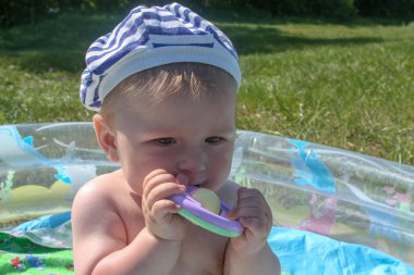 Çocuğun diş kesilir. İlk dişler kesilir, yeşil çim arka planı