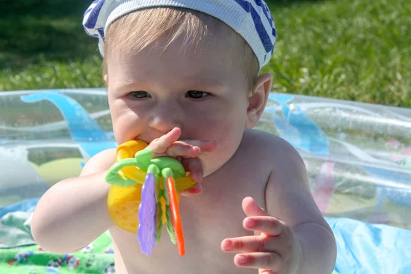 Çocuğun diş kesilir. İlk dişler kesilir, yeşil çim arka planı